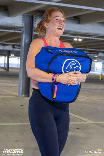 Amanda Alexander carrying a sandbag during outdoor training