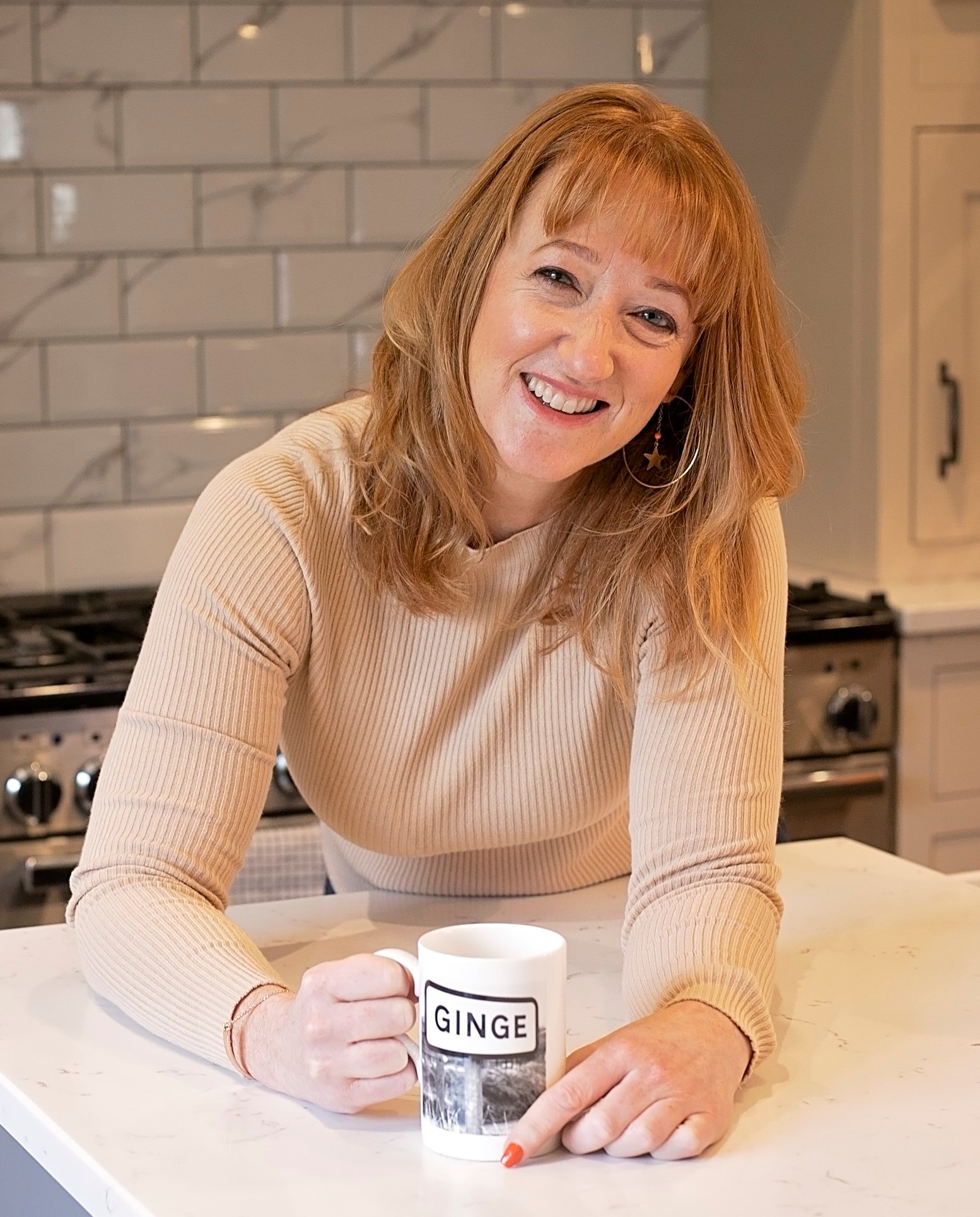 Amanda Alexander, executive coach, holding a mug in the kitchen